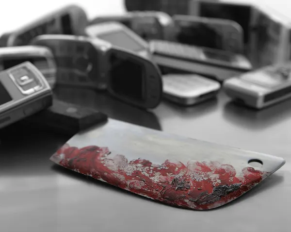 Assorted mobile phones with bloody knife weapon — Stock Photo, Image