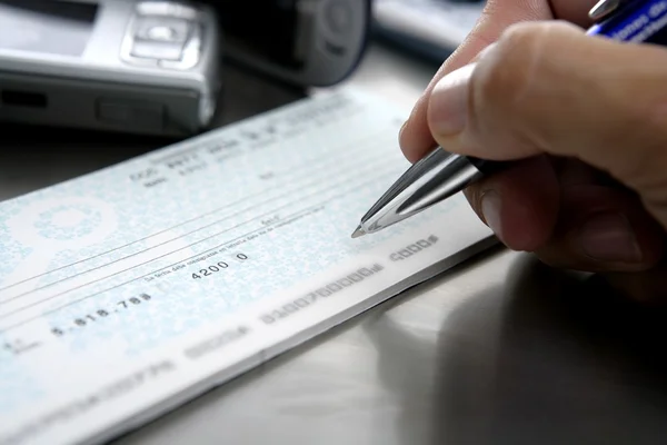 Firmar un cheque. Sign a bank check — Stock Photo, Image