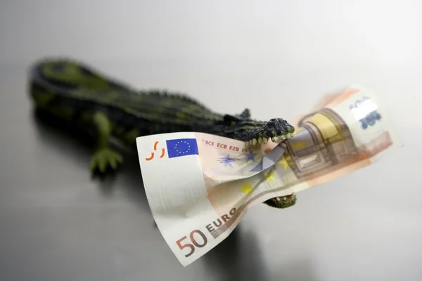 Cocodrile de brinquedo, aligator, com 50 notas de euro nas mandíbulas — Fotografia de Stock
