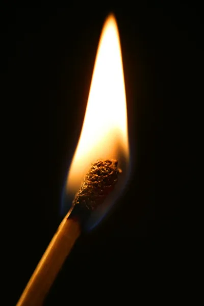 Ein Streichholz in Flammen vor schwarzem Hintergrund — Stockfoto