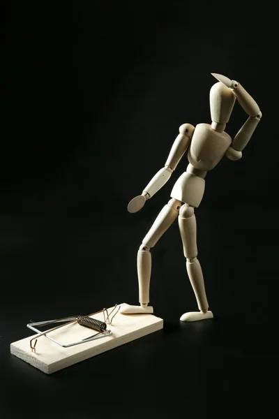 Wooden mannequin with mouse trap, black background — Stock Photo, Image