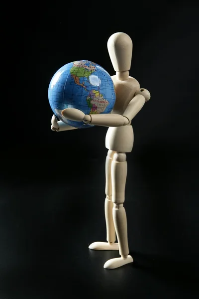 Fából készült kis manöken holding a világ Térkép — Stock Fotó