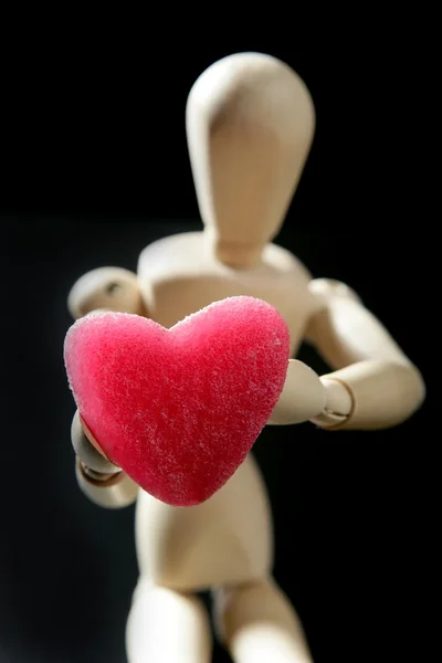 Manichino in legno con una gelatina rossa a forma di cuore — Foto Stock