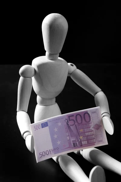 Mannequin en bois, billet de banque en euros, fond noir — Photo