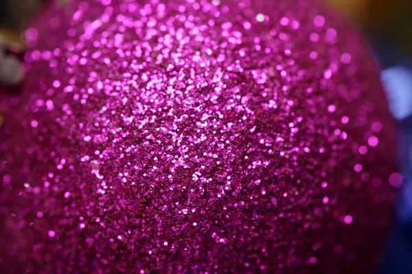 Christmas decoration, purple glitter ball, red background — Stock Photo, Image