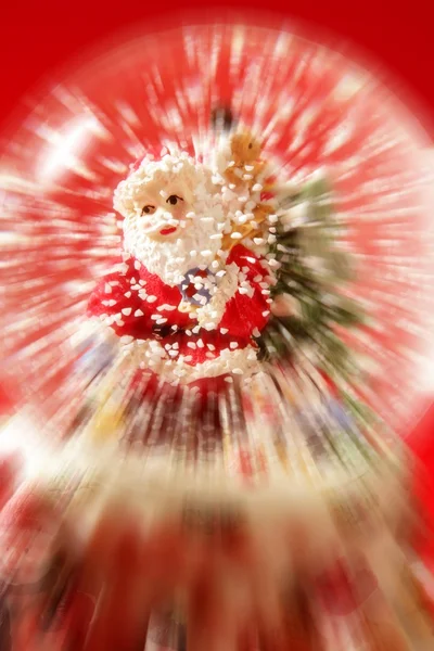 Estatuilla de Santa Claus sobre una bola de cristal nevando — Foto de Stock