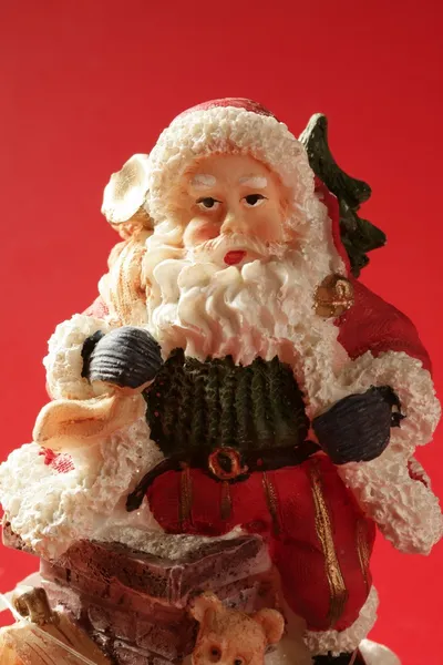 Estatuilla de Santa Claus sobre fondo rojo, estudio —  Fotos de Stock
