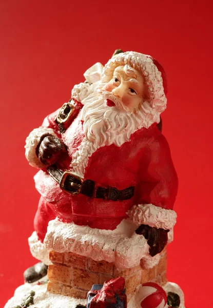 Estatuilla de Santa Claus sobre fondo rojo, estudio — Foto de Stock