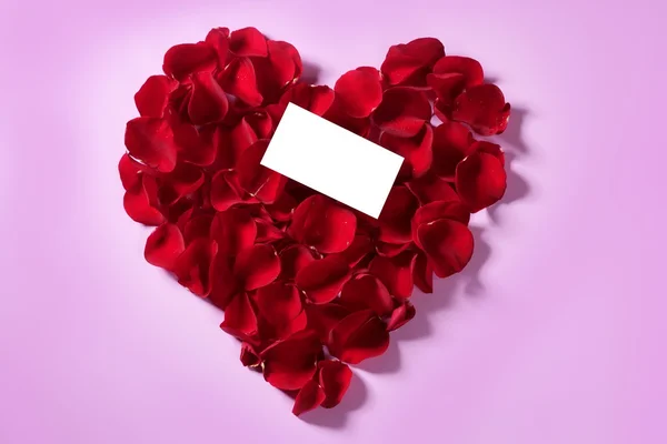 Красные лепестки розы в форме сердца, копия пустой ноты — стоковое фото