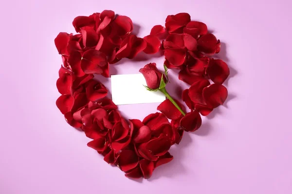 红色玫瑰花瓣放在心的形状，复制空间空白便笺 — 图库照片