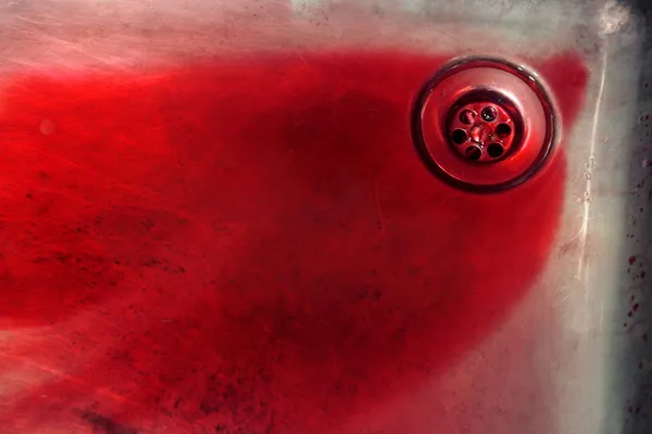 Blood in vivid red in a swtailess steel sink — Stock Photo, Image