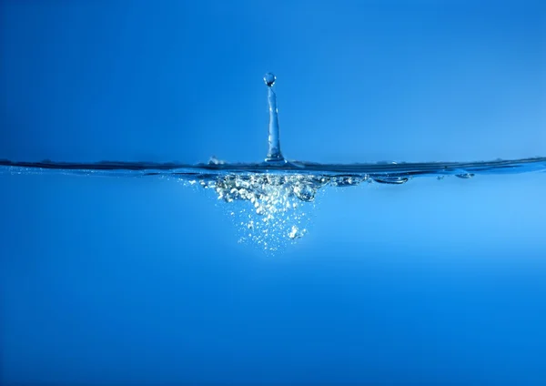 Salpicadura en la superficie de agua azul — Foto de Stock