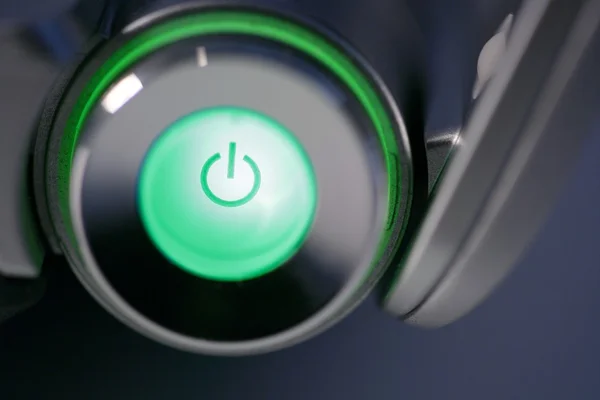 Зелений комп'ютер живлення на кнопці світиться — стокове фото