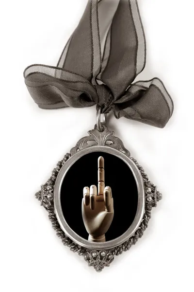 Серебряный медальон с грубым средним пальцем — стоковое фото