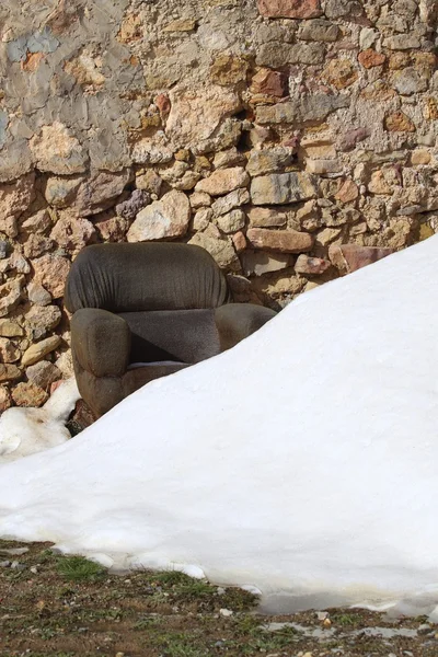 Fauteuil op gesneeuwde stenen metselwerk muur — Stockfoto