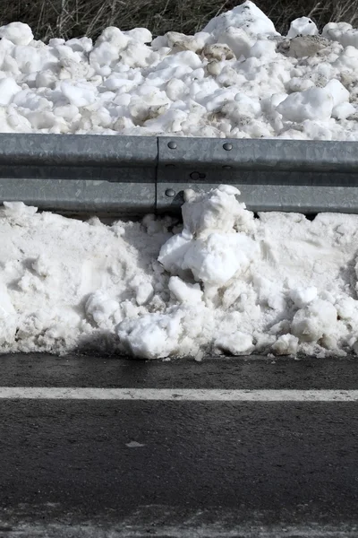 Nieve sobre asfalto carretera frontera valla de acero — Foto de Stock