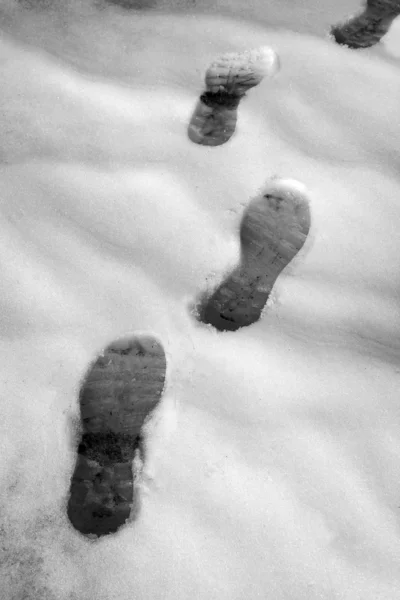 Ίχνη κομμάτι παπούτσια χιόνι στο δρόμο χιονισμένες — Φωτογραφία Αρχείου