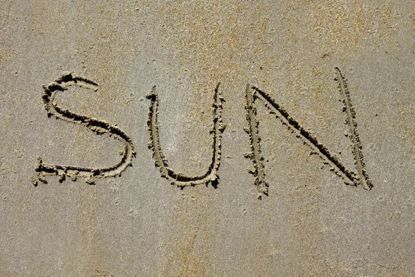 Слово солнце заклинание на пляже влажный летний песок — стоковое фото