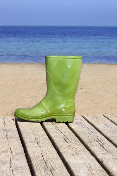 Bota verde en la playa metáfora de pescador desafortunado —  Fotos de Stock