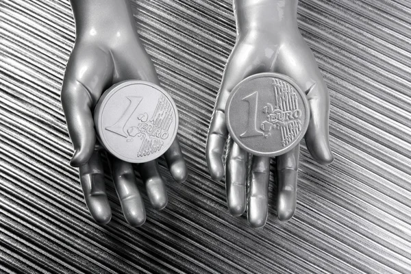 两个银未来派机器人手中的欧元硬币 — 图库照片