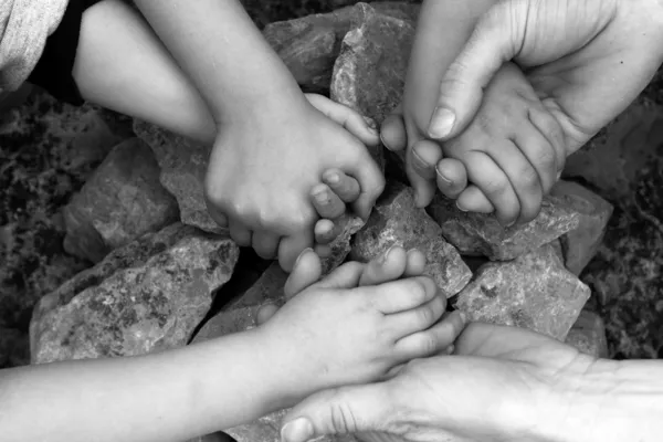 Adultos y niños cogidos de la mano círculo de piedra — Foto de Stock