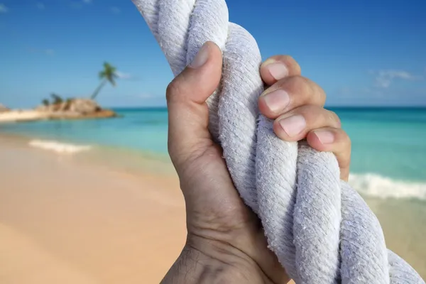 Homem mão agarrar aperto aventura paraíso praia corda — Fotografia de Stock