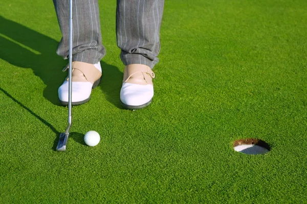 Golf homem curso buraco verde colocando bola curta — Fotografia de Stock