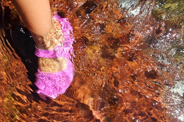 Девочка вода ноги розовый ботинок в речном ручье красное дно — стоковое фото