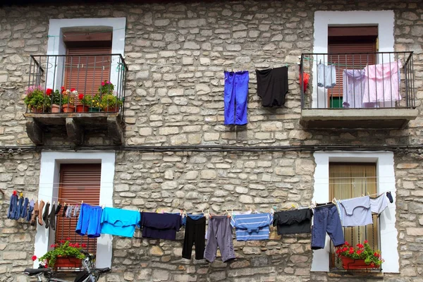 Clothes line hanging from stone wall houses — Stock Photo, Image
