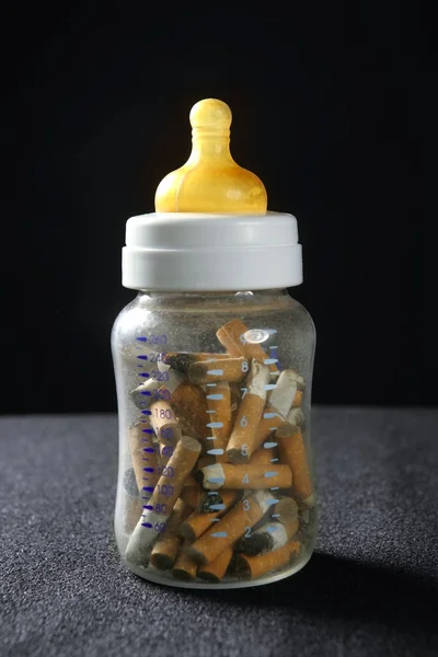 Nicotineverslaving tabak nog steeds baby fles — Stockfoto