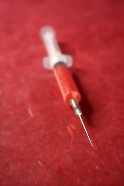 Saúde seringa vermelha sobre fundo vermelho — Fotografia de Stock