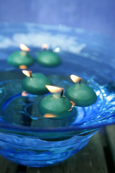 Green candles over blue glass bowl of water — Stock Photo, Image
