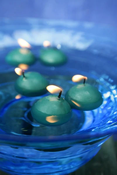 Velas verdes sobre tigela de vidro azul de água — Fotografia de Stock
