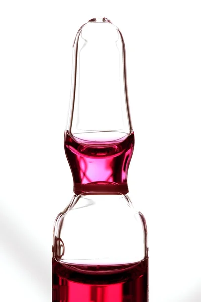 Glass ampoule with red liquid medicine — Stock Photo, Image