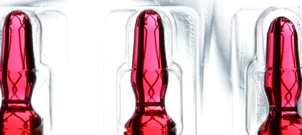 Ampolla de vidrio con medicina líquida roja — Foto de Stock