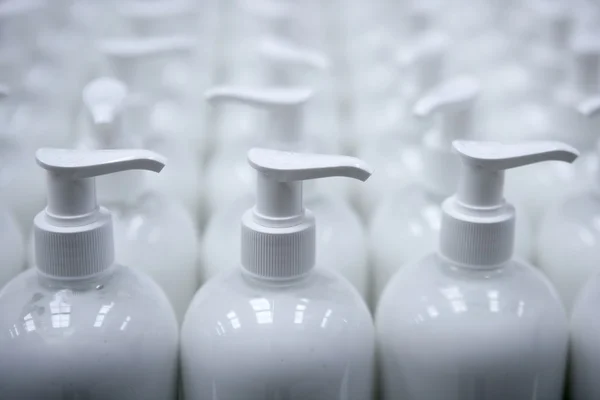 Fehér műanyag szappan palackok a sorok futószalagon — Stock Fotó