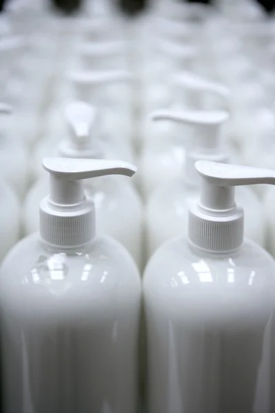 White plastic soap bottles in rows assembly line — Stock Photo, Image