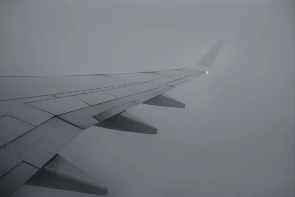 灰色阴天上空飞行的飞机右翼 — 图库照片