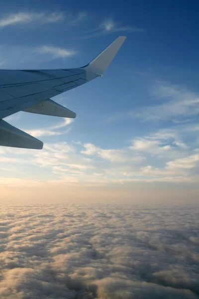 Letadla pravé křídlo, letadlo letící nad mraky v modré obloze — Stock fotografie