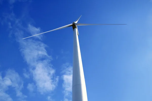 Elektrické větrný mlýn nad modrou oblohu při pohledu z podlahy — Stock fotografie