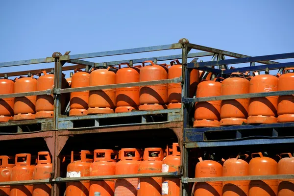 Botellas, bombonas de gas butano color Naranja. Bastidores de gas naranja — Foto de Stock