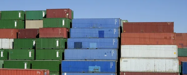 Gestapelde vracht kleurrijke containers, blauwe hemel — Stockfoto