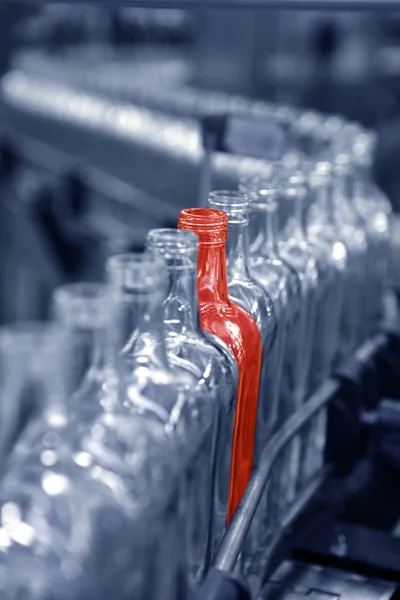 Frasco vermelho único diferente na linha de fábrica — Fotografia de Stock