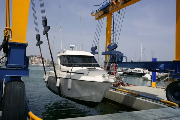 Доккран поднимает рыбацкую лодку — стоковое фото