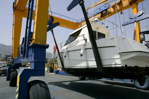 Dock crane elevating a fishing boat — Stock Photo, Image