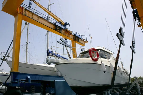 Dok kraan verheffen een vissersboot — Stockfoto