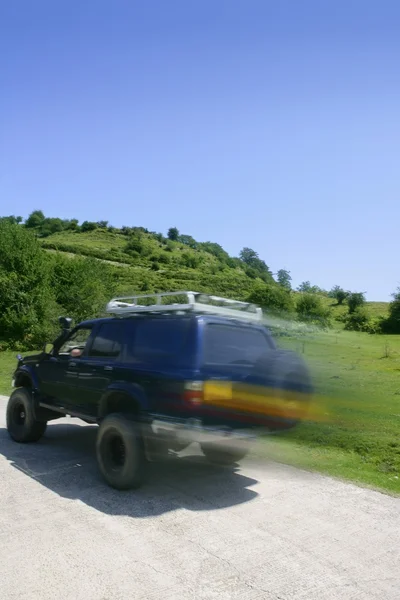 Blurred motion speedy 4x4 truck in meadow — Stock Photo, Image