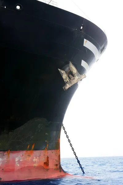 Černá loď zakotvena na modřené mořské vody — Stock fotografie