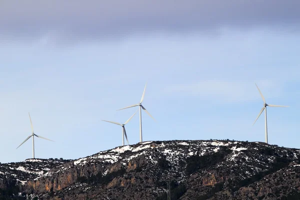 Aerogenerador molinos de viento en la montaña de nieve —  Fotos de Stock