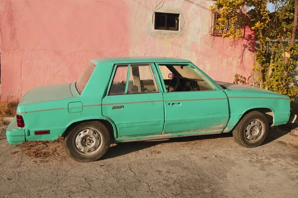 Antiguo coche verde vintage envejecido en la pared rosa — Foto de Stock